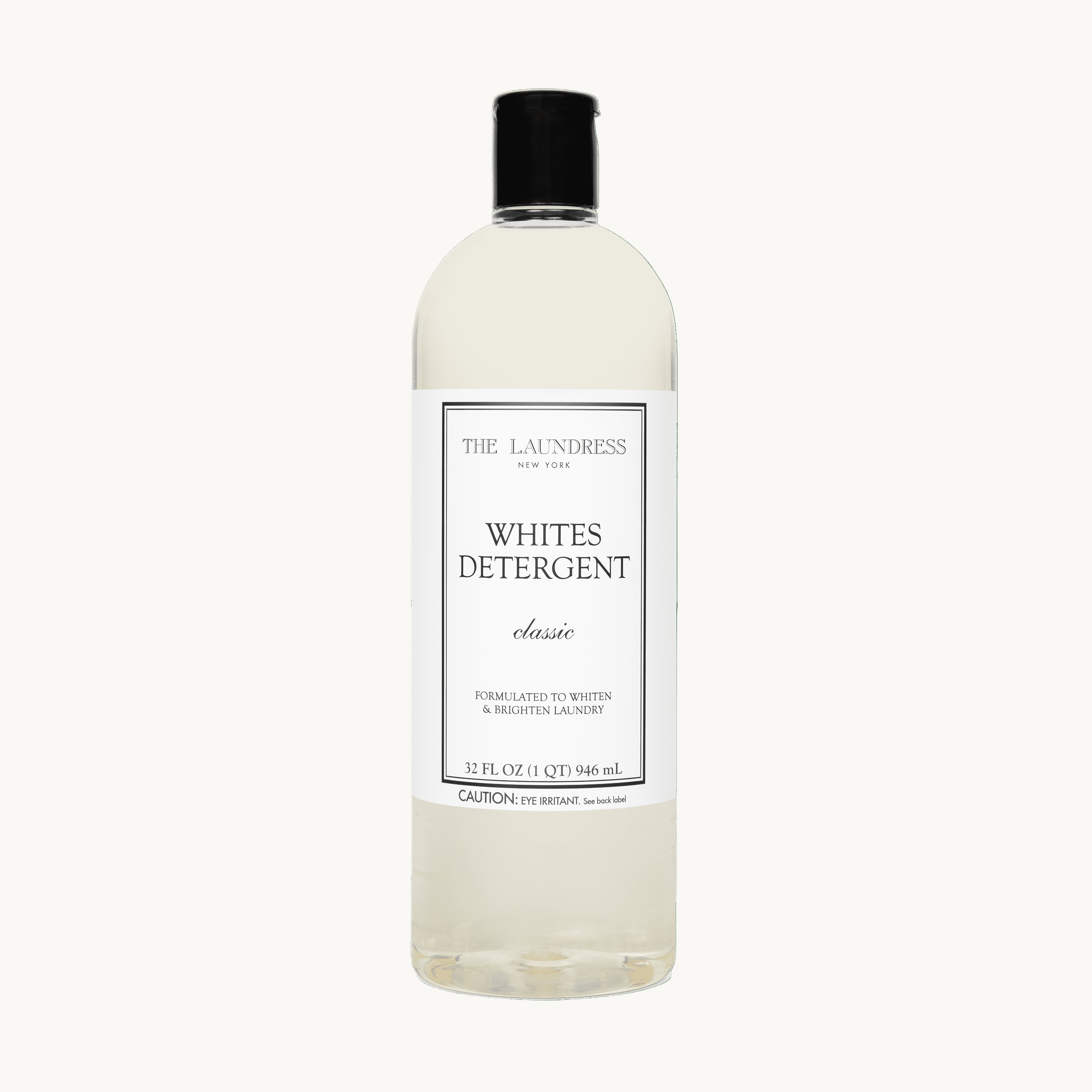 The Laundress Whites Detergent formulated to whiten & brighten laundry laying in water with white fabric.