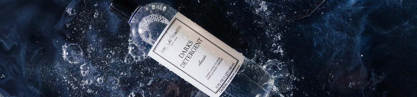 The Laundress Darks Detergent formulated to keep dark laundry vibrant laying in water with dark fabric.