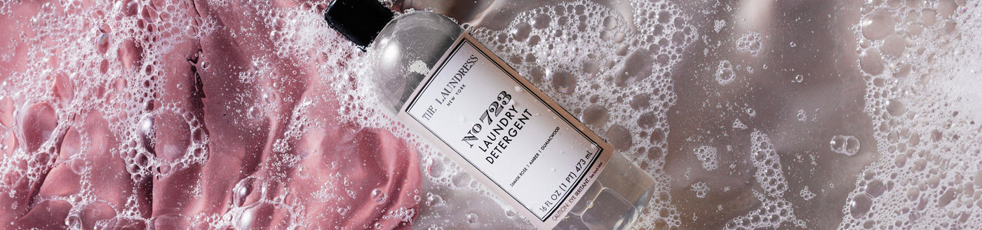 The Laundress No. 723 Laundry Detergent scented with Damask rose, geranium, and amber laying in soapy water.